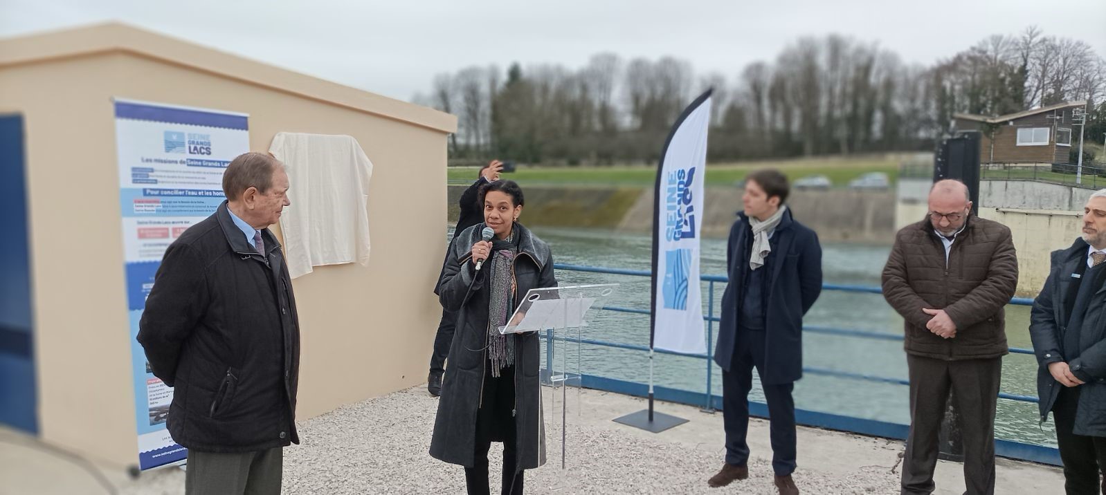 Madame sandrine rocard derrière le pupitre avec un micro 